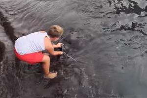 小男孩在水中跟朋友玩耍，當看清楚他玩的生物時讓人徹底傻眼了